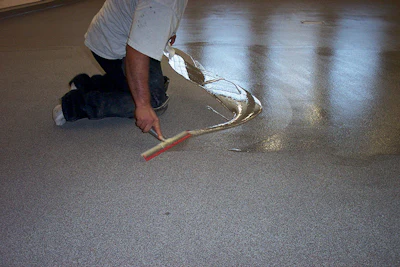 Crews can topcoat a urethane (shown) or epoxy flooring system using squeegees, trowels, and rollers.