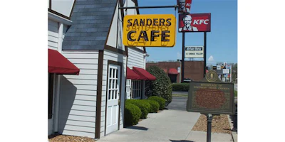 This August 2016 photo, show, the original Sanders Cafe sign, dwarfed by a newer KFC sign and bucket, that tower over the Corbin, Ky., restaurant. KFC says the recipe published in the Chicago Tribune is not authentic. But that hasn't stopped rampant online speculation that one of the most legendary and closely guarded secrets in the history of fast food has been exposed. (Jay Jones/Chicago Tribune via AP)