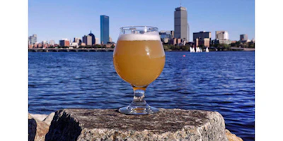 A glass of Castle Island Brewing Company 'Chuck' beer, a dry hopped cream ale, rests on a rock along the bank of the Charles River, Thursday, Sept. 15, 2016, in Cambridge, Mass. Leading New England breweries are competing to see who can turn the questionable water of Boston's Charles River into the tastiest suds. (AP Photo/Charles Krupa)