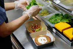 In this Thursday, June 1, 2017, photo, Silvia Ruiz prepares a specialty sandwich at a McDonald's restaurant in Chicago. The company that helped define fast food is making supersized efforts to reverse its fading popularity and catch up to a landscape that has evolved around it. McDonald’s is still trying to shake its image for serving junk food and has made a high-profile pledge to offer healthier options. (AP Photo/Charles Rex Arbogast)