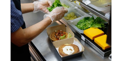 In this Thursday, June 1, 2017, photo, Silvia Ruiz prepares a specialty sandwich at a McDonald's restaurant in Chicago. The company that helped define fast food is making supersized efforts to reverse its fading popularity and catch up to a landscape that has evolved around it. McDonald’s is still trying to shake its image for serving junk food and has made a high-profile pledge to offer healthier options. (AP Photo/Charles Rex Arbogast)