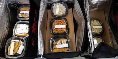 This May 10, 2018 photo shows catered lunches packed in containers to deliver to Kipling Elementary School in Highland Park, Ill. Food-delivery services are remaking school lunch. Many parents still make their kids' lunch, of course, or sign up for a hot-lunch program through school. But others are ordering from companies that deliver meals to home or school. Kiddos Catering in Chicago has come up with a different twist: providing restaurant meals to schools that contract with it. (AP Photo/Nam Y. Huh)