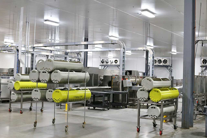 The HPP plant at Universal Pure's Villa Rica, Georgia headquarters. Food, already sealed in its package, is loaded into these gray and yellow canisters and sent through the HPP vessel behind them where water and high pressure are applied to inactivate foodborne pathogens to enhance food safety and extend shelf life.