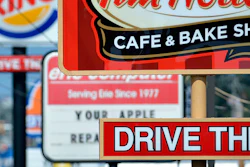FILE - In this Tuesday, Aug. 26, 2014 file photo, fast food restaurant signs line Peach Street in Erie, Pa. A Centers for Disease Control and Prevention study released on Wednesday, Oct. 3, 2018 finds that one in three U.S. adults eat fast food on any given day. (Christopher Millette/Erie Times-News via AP)