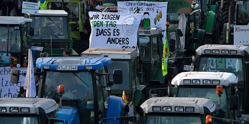 Demonstrators protest with tractors for more animal welfare and protection in the agriculture on occasion of the 'Green Week' fair in front of the Brandenburg Gate in Berlin, Germany, Saturday, Jan. 19, 2019. ( Ralf Hirschberger/dpa via AP)