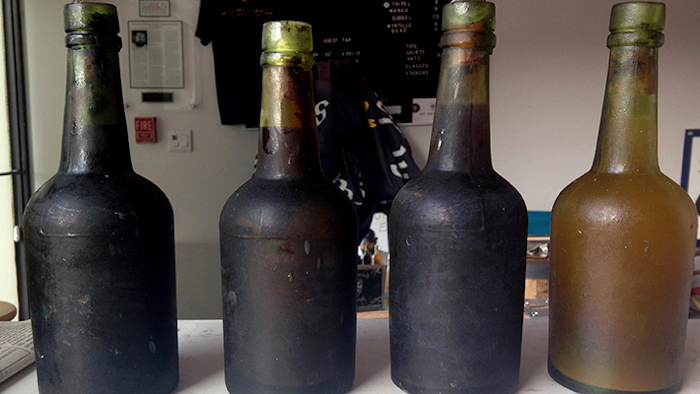 In this July 17, 2017 photo provided by Jamie Adams, four bottles recovered from the SS Oregon, a 133-year-old shipwreck, are shown at the Saint James Brewery in Holbrook, N.Y. Bill Felter of Serious Brewing in Howes Cave, N.Y., hoped to develop a new brew from ale salvaged from the SS Oregon. But the scuba-diving Long Island brewer, Adams, has scuttled those plans, saying he owns the shipwreck yeast and has used it to produce ale he’s releasing in March 2019. (Jamie Adams via AP)
