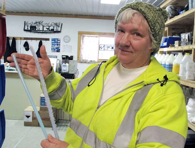 In this Wednesday, March 13, 2019, photo, Ruth Goodrich of Goodrich's Maple Farm in Danville, Vt., holds squirrel-damaged maple sap tubing, right, and new tubing, left, in the farm's equipment shop. An abundant squirrel population is wreaking havoc on some maple operations in the Northeast as the season gets off to a late start. (AP Photo/Lisa Rathke)