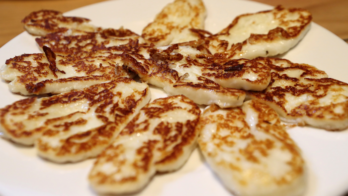 In this photo taken Wednesday Dec. 11, 2019, Cyprus' halloumi cheese is seen roasted on a plate at 'Riverland' farm in Kampia village near Nicosia, Cyprus. Cyprus' halloumi cheese, with a tradition dating back some five centuries, is the island nation's leading export. It's goat and sheep milk content makes it a hit with health-conscious cheese lovers in Europe and beyond. It's added appeal is that unlike other cheeses, it doesn't melt when heated up.