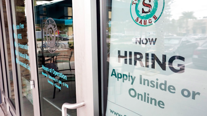 In this Nov. 4, 2019, file photo a job posting is displayed near the entrance outside a restaurant in Orlando, Fla. Two reports last week show that small business hiring still lags behind the strong job growth reported at larger companies, and that owners are unlikely to increase their staffs significantly in 2020.
