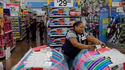In this Nov. 27 file photo, Balo Balogun labels items in preparation for a holiday sale at a Walmart Supercenter in Las Vegas.