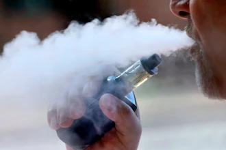 In this Aug. 28, 2019 file photo, a man exhales while smoking an e-cigarette in Portland, ME.