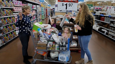 In this Nov. 27, 2019 file photo, from left, Tina Fausto, left, and Olivia Wirtshafter, right, shop with Lilly Flores, second from left, and Laly Rose Stanton the day before the Thanksgiving holiday at a Walmart Supercenter in Las Vegas.