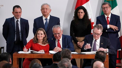 Deputy Prime Minister of Canada Chrystia Freeland, left, Mexico's top trade negotiator Jesus Seade, center, and U.S. Trade Representative Robert Lighthizer, sign an update to the North American Free Trade Agreement, at the national palace in Mexico City on Tuesday, Dec. 10. Observing from behind are Mexico's Treasury Secretary Arturo Herrera, left, Mexico's President Andres Manuel Lopez Obrador, second left, Mexico's Labor Secretary Maria Alcade, third left, and The President of the Mexican Senate Ricardo Monreal.