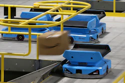 In this Dec. 17 photo, an Amazon robot sends a package down a chute, transporting packages from workers to chutes that are organized by zip code, at an Amazon warehouse facility in Goodyear, AZ. The tech giant is still rolling out new models descended from the Kiva line, including the Pegasus, a squarish vehicle with a conveyor belt on top that can be found working the early-morning shift at a warehouse in the Phoenix suburb of Goodyear.