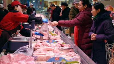 People shop for meat a supermarket in Handan in northern China's Hebei Province on Thursday, Jan. 9.
