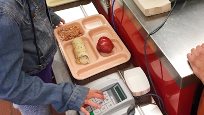 In this May 4, 2017 file photo, a third-grader punches in her student identification to pay for a meal at Gonzales Community School in Santa Fe, NM.