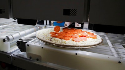 Picnic's pizza-making robot makes a pizza at a food vendor's booth during the CES tech show, Wednesday, Jan. 8, 2020, in Las Vegas.