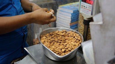 In this June 22, 2019 file photo, a shopkeeper weighs California almonds for a customer at a shop in New Delhi, India. Almonds used to have about 170 calories per serving, then researchers said it was really more like 130. A little later, they said the nuts may have even less. The shifting numbers for almonds show how the figures stamped on nutrition labels may not be as precise as they seem.