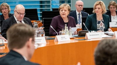 German Chancellor Angela Merkel, center, speaks alongside Peter Altmaier, Federal Minister of Economics and Energy, left, and Julia Klöckner, Federal Minister of Food and Agriculture, at the beginning of a meeting of the Federal Government with representatives of the food industry in Berlin, Germany on Monday, Feb.3.