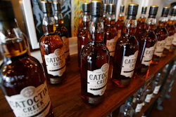 In this June 20, 2018 file photo, Catoctin Creek Distillery whiskey is on display in a tasting room in Purcellville, VA. A new spirits industry report says President Donald Trump's trade war dampened the overseas market for American-made whiskey last year. The Distilled Spirits Council says overall exports of bourbon, Tennessee whiskey and rye whiskey tumbled amid a trade war-induced decline in exports to key European markets.