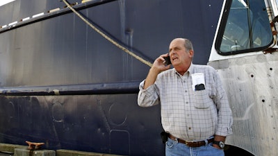 In this Oct. 14, 201, file photo, Carlos Rafael talks on the phone at Homer's Wharf near his herring boat F/V Voyager in New Bedford, MA. A Massachusetts company is slated to acquire in 2020 what's left of the boats once owned by Rafael, who was forced out of the industry after an elaborate fraud. The fishing magnate, known as the Codfather, was sentenced in 2017 to nearly four years in prison after pleading guilty to evading fishing quotas and smuggling money to Portugal. (