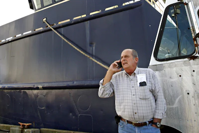 In this Oct. 14, 201, file photo, Carlos Rafael talks on the phone at Homer's Wharf near his herring boat F/V Voyager in New Bedford, MA. A Massachusetts company is slated to acquire in 2020 what's left of the boats once owned by Rafael, who was forced out of the industry after an elaborate fraud. The fishing magnate, known as the Codfather, was sentenced in 2017 to nearly four years in prison after pleading guilty to evading fishing quotas and smuggling money to Portugal.