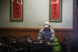 In this Feb. 13 photo, Frankie Chu, owner of Vegetarian Dim Sum House in New York's Chinatown, sits in his empty restaurant usually bustling with customers, in New York. Sales have plunged 70% over the last two weeks, 'I don't know how long I can stay here,' Chu said. 'After 9/11, it wasn't this bad.'