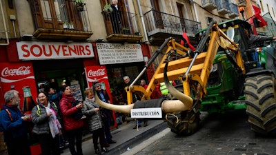 A farmer blocks the center of the city with his tractors during a protest in Pamplona, northern Spain on Wednesday, Feb. 19. Farmers across Spain are taking part in mass protests over what they say are plummeting incomes for agricultural workers.