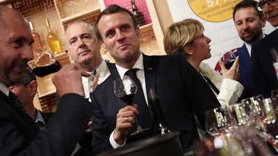French President Emmanuel Macron drinks wine during a visit to the International Agriculture Fair (Salon de l'Agriculture) at the Porte de Versailles exhibition center in Paris on Saturday, Feb. 22.