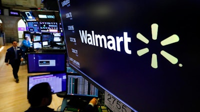 In this Feb. 18, 2020 file photo, the logo for Walmart appears above a trading post on the floor of the New York Stock Exchange. Walmart is confirming that it's developing a competitor to Amazon's juggernaut Prime membership program. The company declined on Thursday, Feb. 27 to offer details, but a spokeswoman said it will be called Walmart+.
