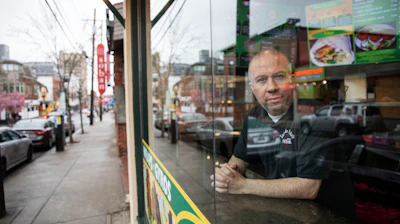 Paul Boutros, owner of East Side Pockets, a small restaurant near Brown University, looks out onto an empty street since students were sent home two weeks ago on Wednesday, March 25 in Providence, R.I.