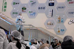 In this Thursday, Feb. 27 photo, journalists dressed in protective overalls visit the Mengniu dairy factory in Beijing. Reporters were invited to China Mengniu Dairy Co. Ltd. last week to be shown how companies are reviving after anti-virus measures shut down most of the world's second-biggest economy.