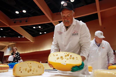 Steve Stettler holds a wheel of baby Swiss cheese at the biennial World Championship Cheese Contest on Tuesday, March 3 at the Monona Terrace Convention Center in Madison, WI.