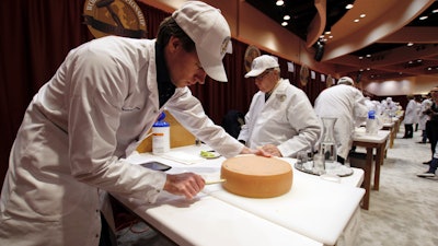 Judge Douwe Dijkstra pulls out a piece of Appenzeller cheese at the biennial World Championship Cheese Contest on Tuesday, March 3 at the Monona Terrace Convention Center in Madison, WI. It's the largest technical cheese, butter and yogurt competition in the world. This year the competition had a record 3,667 entries from 26 nations.