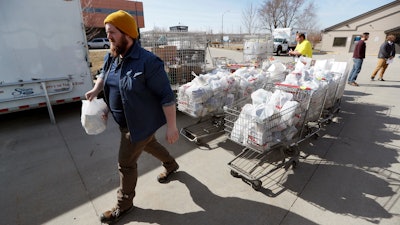 In this Tuesday, March 17 photo, Patrick Minor loads food onto a delivery truck at the Des Moines Area Religious Council food pantry in Des Moines, IA. With the new coronavirus leaving many people at least temporarily out of work, food banks and pantries across the U.S. are scrambling to meet an expected surge in demand, even as older volunteers have been told to stay home and calls for social distancing have complicated efforts to package and distribute food.