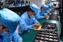 In this Feb. 13, 2020, photo released by Xinhua News Agency, workers wearing masks labor at a factory for Chinese telecommunications company OPPO.