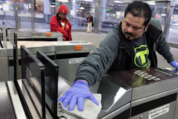 In this March 13 photo, a worker disinfects a turnstile at the Government Center transit stop, in Boston. As the global viral pandemic grows, the need for cleaning and disinfecting has surged. Cleaners and domestic workers are essential in the effort to contain the virus.