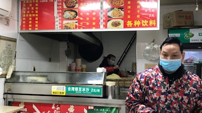 Stores owners of a store selling a local favorite 'reganmian,' or 'hot dry noodles,' prepare takeaway orders in Wuhan in central China's Hubei province on Tuesday, March 31. The reappearance of Wuhan's favorite noodles is a tasty sign that life is slowly returning to normal in the Chinese city at the epicenter of the global coronavirus outbreak. The steady stream of customers buying bags of noodles smothered in peanut sauce testifies to a powerful desire to enjoy the familiar again after months of strict lockdown.