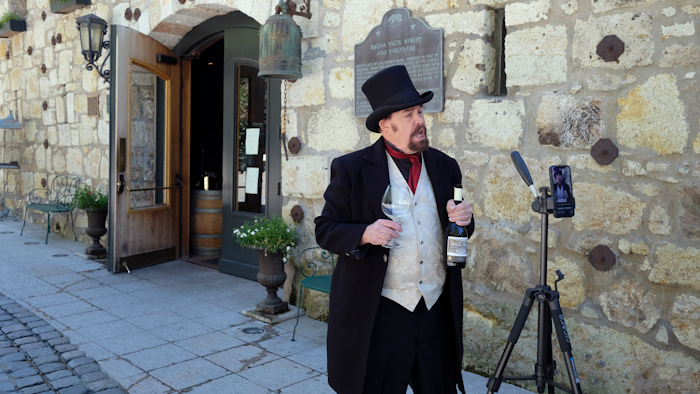 In this photo taken Wednesday, April 1, George Webber, dressed as 'The Count' Agoston Haraszthy, leads a virtual online tasting and tour of the historic Buena Vista Winery in Sonoma, CA. The winery is the state's oldest commercial winery dating to 1857. Wineries that want to stay viable and connected to their customers during the coronavirus pandemic are harnessing platforms such as Facebook Live to offer virtual wine experiences.