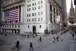 In this March 18 file photo, a few people walk on Wall Street in front of the New York Stock Exchange in New York. There are emerging signs that any recovery will fail to match the speed and severity of the economic collapse that occurred in just a few weeks.