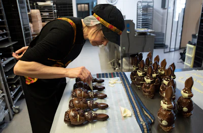 In this photo taken on Wednesday, April 8, Genevieve Trepant decorates chocolate rabbits at her shop, Cocoatree, in Lonzee, Belgium.