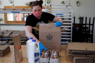 Monica Mileur packs grocery items into a box at Union Loafers restaurant on Friday, April 10 in St. Louis. Some restaurants have turned to selling groceries and other provisions to customers as a way to help make up for revenue lost during the coronavirus outbreak.