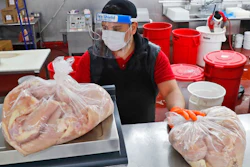 Amid concerns of the spread of COVID-19, Giovani Garcia weighs chicken at the butcher counter of El Rancho grocery store in Dallas, Monday, April 13, 2020.