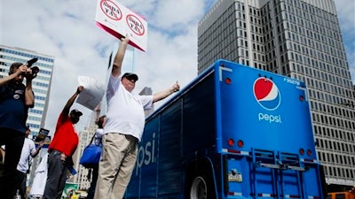In this June 8, 2016 file photo, opponents of a proposed sugary drink tax demonstrate outside City Hall in Philadelphia. Philadelphia is set to become the first major American city with a soda tax despite a multimillion-dollar campaign by the beverage industry to block it. The City Council is expected to give final approval Thursday, June 16, 2016, to a 1.5 cent-per-ounce tax on sugary and diet beverages.