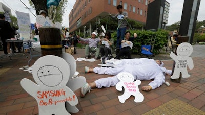 In this May 1, 2016 photo, members of the electronics industry workers advocacy group Banolim perform during a rally against the electronics giant's response to former employees' health concerns on a street in Seoul, South Korea.