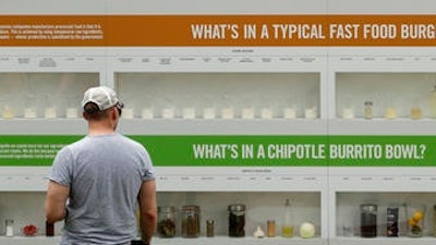 A man looks at a display contrasting processed and fresh food at Chipotle's Cultivate Festival in Kansas City, Mo. Cultivate festivals encapsulate the food industry’s hottest marketing trend: crusading against Big Food.