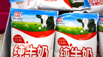 In this Saturday, March 25, 2017 photo, bags of Huishan milk sit on a shelf in a grocery store in Shenyang in northeastern China's Liaoning province. China Huishan Dairy Holdings Co., a Chinese dairy company, whose stock plunged last week, wiping billions off its market value, denied rumors Tuesday, March 28 of forged invoices and misappropriated funds, but also said it can't contact a key executive.