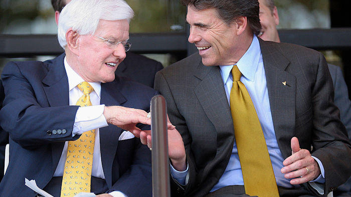 In this Sept. 18, 2005, photo, Lonnie 'Bo' Pilgrim, CEO and Chairman of the Board of Board of Pilgrim's Pride Chicken, left, shakes hands with Texas Gov. Rick Perry at the Dedication Open House of the companies new headquarters in Pittsburg, Texas. Pilgrim, who grew a one-time feed store into the world's largest poultry producer before losing the company in bankruptcy, has died at 89. A statement on the Erman Smith Funeral Home website says Pilgrim died Friday, July 21, 2017, at his Pittsburg home.