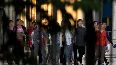 In this Aug. 31, 2017, photo, North Korean workers walk in a group to dormitories in the compound of the seafood processing factory Hunchun Pagoda in the city of Hunchun in northeastern China's Jilin province. Roughly 3,000 North Koreans are believed to work in Hunchun, a far northeast Chinese industrial hub just a few miles from the borders of both North Korea and Russia. The workers are paid a fraction of their salaries, while the rest - as much as 70 percent - is taken by North Korea’s government.