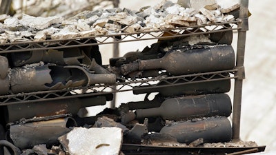 The remains of burned bottles of wine are seen at the Signorello Estate winery Tuesday, Oct. 10, 2017, in Napa, Calif. Worried California vintners surveyed the damage to their vineyards and wineries Tuesday after wildfires swept through several counties whose famous names have become synonymous with fine food and drink.